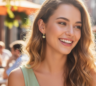 A model wearing Sunburst drop earrings, a radiant and elegant pair of earrings with a striking sunbeam-shaped pendant, crafted from 18-karat gold-plated stainless steel.