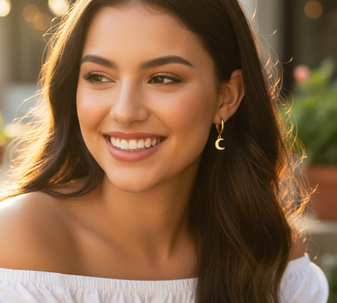 A model wearing Moon Drop drop earrings, with a delicate moon-shaped pendant that hangs elegantly from the ear, made from 18-karat gold-plated stainless steel.