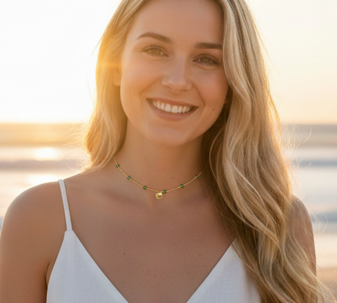 Green Zircon Shell Necklace. This little beauty is an absolute cracker! A delicate choker necklace with sparkling green zircons and a small shell charm, all crafted in 18K gold-plated stainless steel. Looks unreal on our model, especially with that sunset glow.