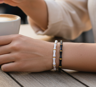 Eterna Band Bracelet, a chic and modern bracelet featuring a bold design of connected black enamel and gold segments, crafted in 18K gold-plated stainless steel, and displayed on a white background.