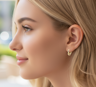 A model wearing a pair of earrings with three gold rings, each adorned with a sparkling moissanite gemstone, crafted from high-quality 18-karat gold-plated sterling silver.