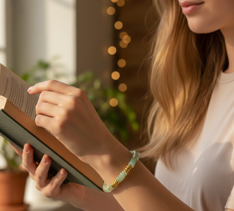 A model showcasing a green aventurine gemstone bracelet. Its vibrant, energy-activated stones catch the light and add a playful touch to her outfit.