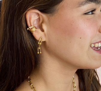 Young woman wearing the no-piercing Twisted Vines ear cuff from Keira K, styled as part of an ear stack.