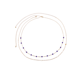 Close-up shot focusing on the deep blue zircon of the Azure Mirage Body Chain on its gold-plated chain.