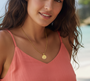 Celestial Trio Necklace. This little beauty is a real ripper! It's a gorgeous 18K gold-plated stainless steel necklace featuring a stunning sun, moon, and star design. As you can see, it looks an absolute treat on our model, especially with that beach backdrop.