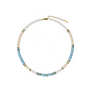 Alt text: The Salty Glow Shell Necklace in Ocean Blue, featuring white and light blue shell beads with 18k gold accents.