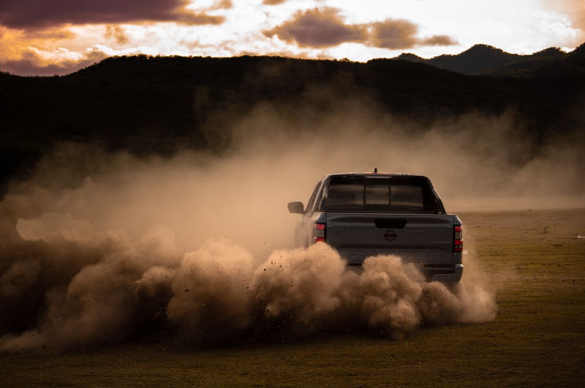 Pickup truck kicking up dust at sunset