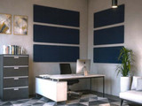 Modern office with a desk, computer, filing cabinet, and dark blue acoustic wall panels installed behind the workspace.