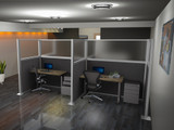 Two office desks enclosed by gray cubicle partition panels with computers, chairs, and storage cabinets in a modern workspace.