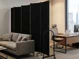 Office lounge with a gray sofa and desk, separated by tall black fabric privacy panels on wheels.