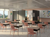Classroom with student desks, chairs, and wheeled divider panels separating learning areas.