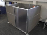 Gray fabric office cubicle with a frosted sliding door and aluminum frame panels