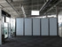 Large open interior with a long row of gray wheeled divider panels blocking part of a terminal-like space.