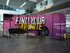 Wheeled divider panels in a modern lobby displaying a colorful automotive-themed promotional graphic.