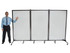 Man standing beside a three-panel wheeled whiteboard divider on a white background.