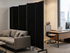 Office lounge with a gray sofa and desk, separated by tall black fabric privacy panels on wheels.