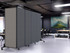 Gray rolling partition panels dividing a modern office workspace with desks, chairs, and a large wall artwork.