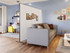 Living room with a gray sofa divided by a freestanding white partition, separating it from a small home office area.