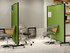 Clinic-style room with green rolling privacy panels and adjustable chairs arranged for workstation separation.