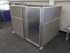 Gray fabric office cubicle with a frosted sliding door and aluminum frame in an open workspace.