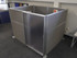 Gray fabric office cubicle with a frosted sliding door and aluminum frame panels