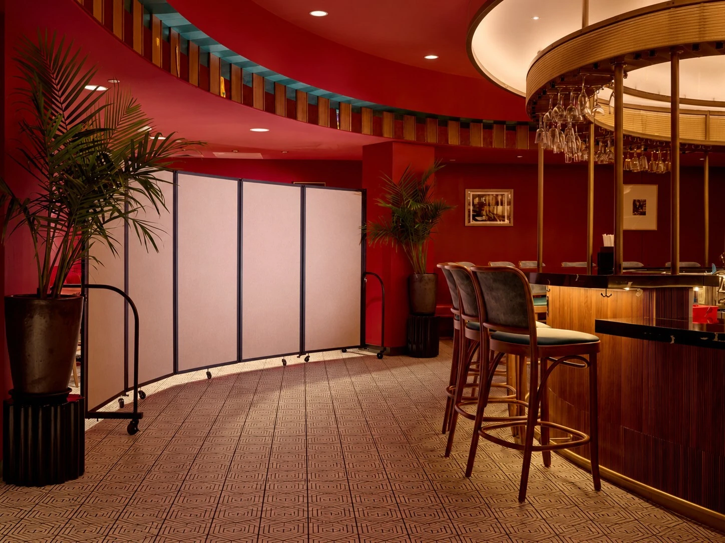 Screenflex portable room divider creating a private area beside a restaurant bar.
