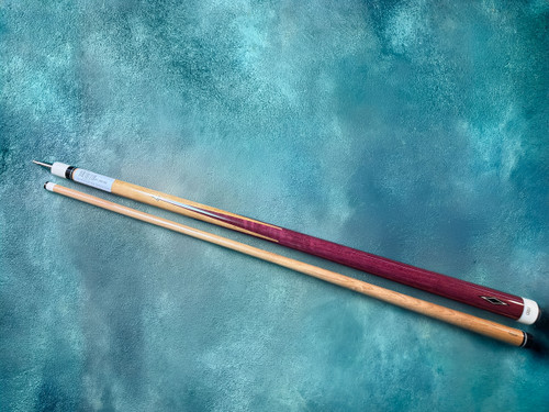 Full spliced purpleheart Giuli Sneaky Pete pool cue with Keilwood shaft laid on teal textured background