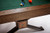 Brunswick Dameron pool table rail detail with hand hammered metal sights and nutmeg finish with x base legs 