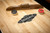 Brunswick Parsons rustic modern shuffleboard table showing included pucks and board sweep

