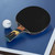 Cornilleau Excell 2000 Carbon paddle resting on indoor table tennis table ready for offensive play