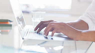 A person typing on a laptop, symbolizing the support of family and friends in quitting.