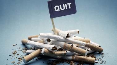 Bunch of broken cigarette with the flag of Quit