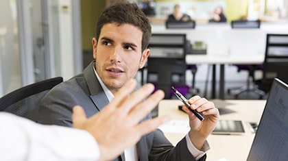 Someone reaching out a hand to stop a man in a blazer from vaping