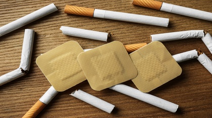 broken cigarettes and nicotine patches to help someone stop smoking