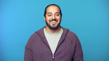 A bearded man dressed in a purple sweater, symbolizing a new beginning focused on dental hygiene and overcoming smoking habits.