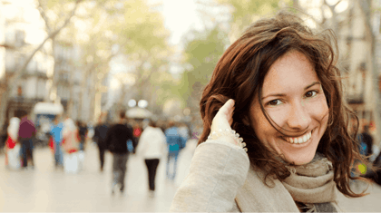 Woman smiling at the camera with hand in her hair