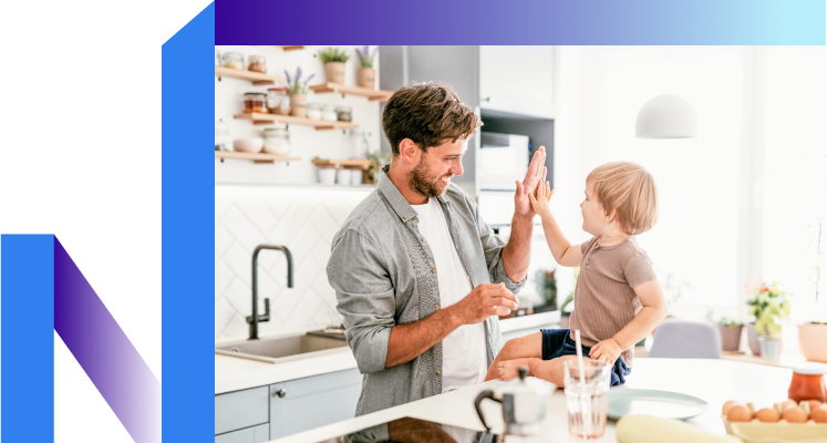 A man and a child joyfully high-five in a bright kitchen, celebrating their connection.