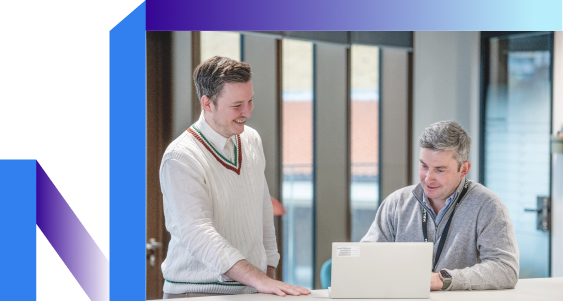 A man showing his laptop screen to his colleague