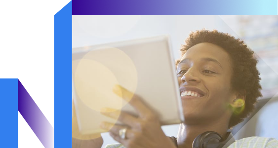 A person smiling while holding a tablet, with headphones resting around their neck.