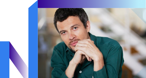 A man in a green shirt gazes at the camera with a neutral expression.