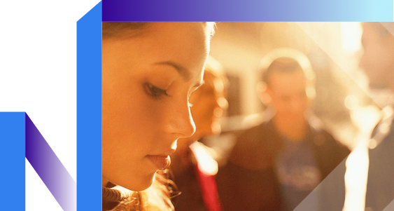A woman looks at her phone as pedestrians pass, showcasing solitude in a busy environment.