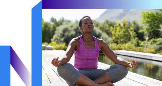 A woman meditates in a yoga pose on a tranquil dock