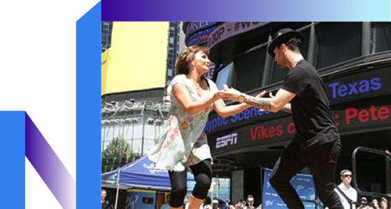 A man and woman showcase their skills, entertaining a vibrant crowd with their energy.