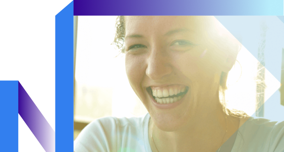 A woman smiles as sunlight filters