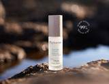 A bottle of Phytocéane wrinkle and firmness serum with a wooden cap, set against a blurred natural background.