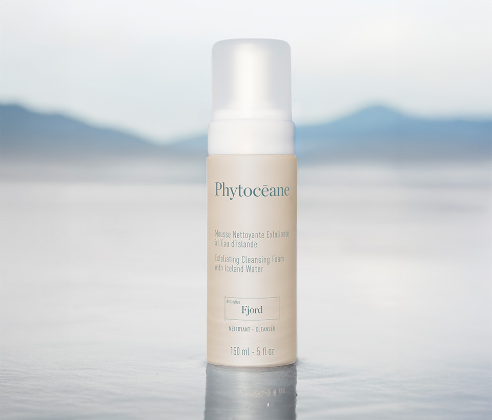 Phytoceane  Exfoliating Cleansing Foam with Iceland Water sitting in water with grey misty mountains in the background/
