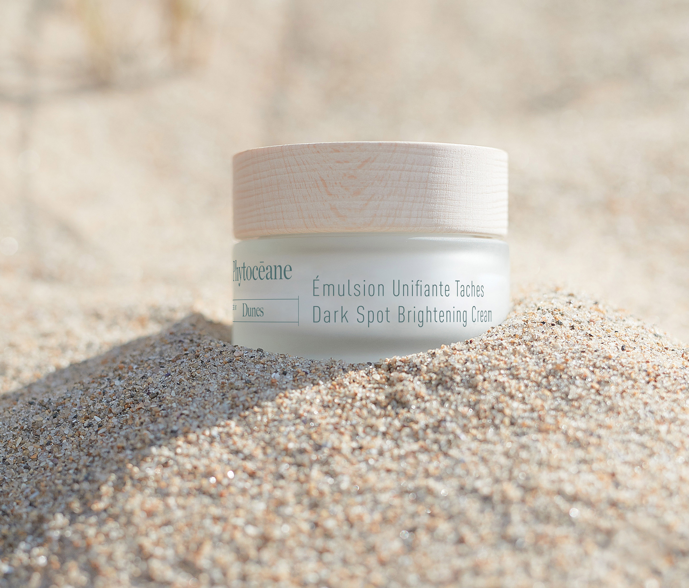 Destination Dunes Dark Spot Brightening Cream on a sandy beach