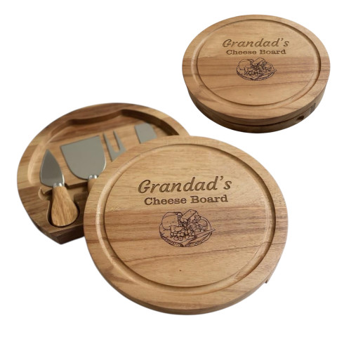 A round wooden cheese board with a swivel top, featuring the engraved text "Grandad's Cheese Board" and a engraved graphic of cheese. The board includes a hidden compartment containing three stainless steel cheese servers with wooden handles.