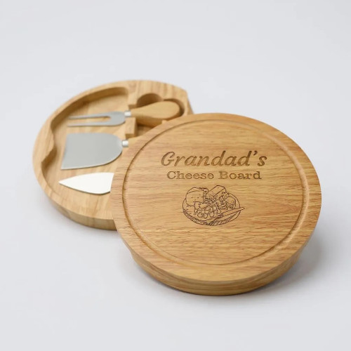 A wooden circular charcuterie board. Made from rubberwood with sliding opening lid to reveal 3 cheese servers. Customised text on top of lid with engraved stunning cheese and grapes design. A wooden circular charcuterie board. Made from rubberwood with sliding opening lid to reveal 3 cheese servers. Customised text on top of lid with engraved stunning cheese and grapes design.