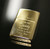 Close-up of polished brass Zippo lighter engraved with personalised message, part of luxury gift set